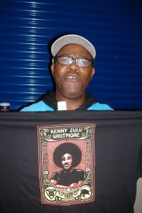 Billy X holding a Free Zulu shirt